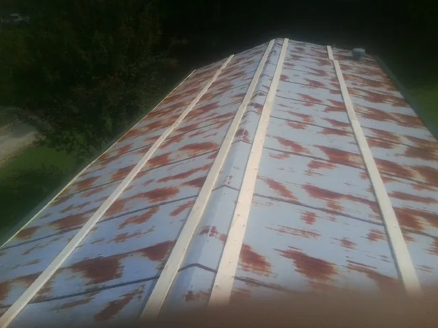 Rusted metal roof panels with new wood purlins before replacement — Storm Damage Roof Repair in Cairo by Roofing Brothers