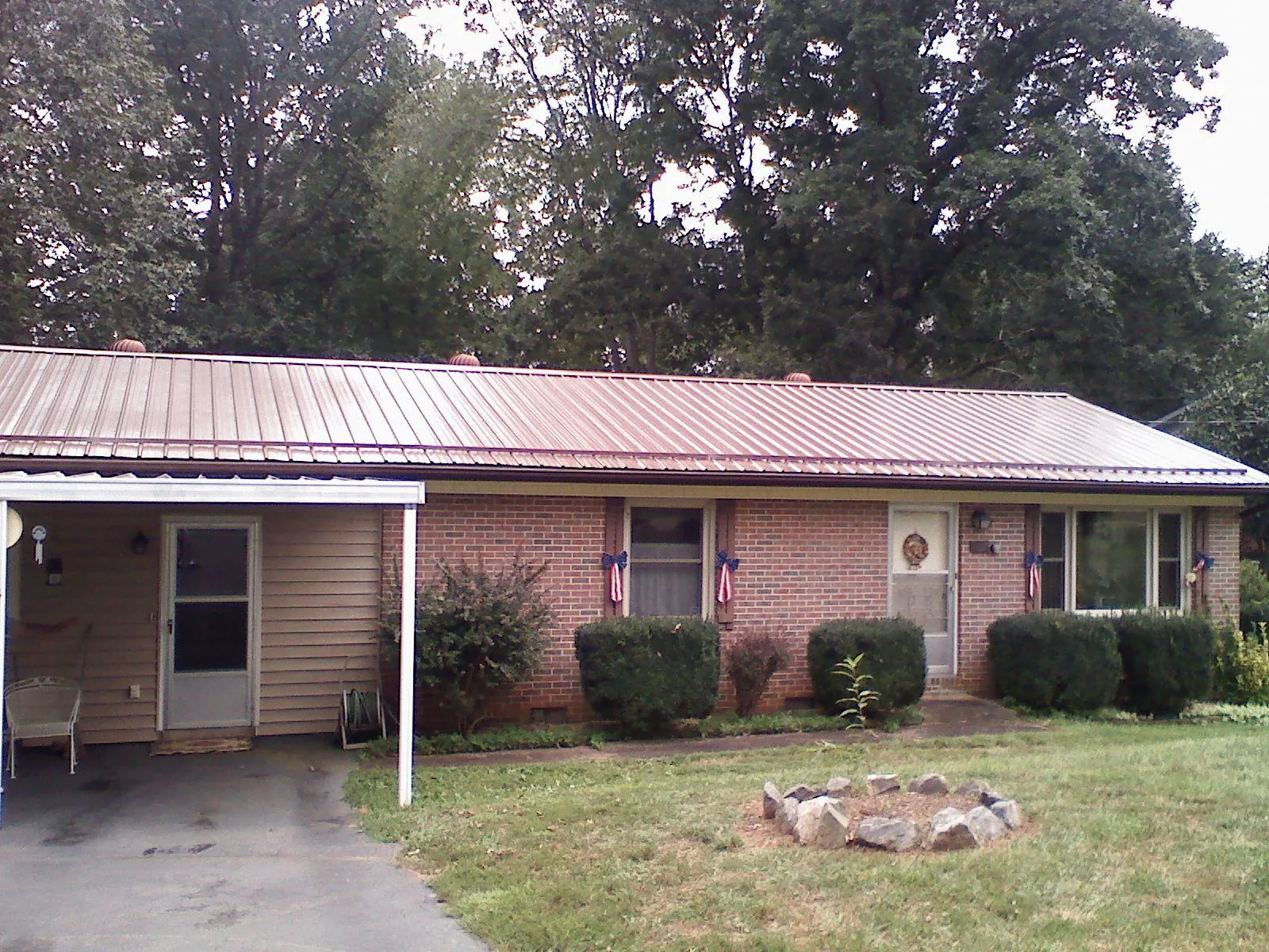 Bronze metal roof and carport on a brick ranch home — Roof Repair work by our crew in Cairo